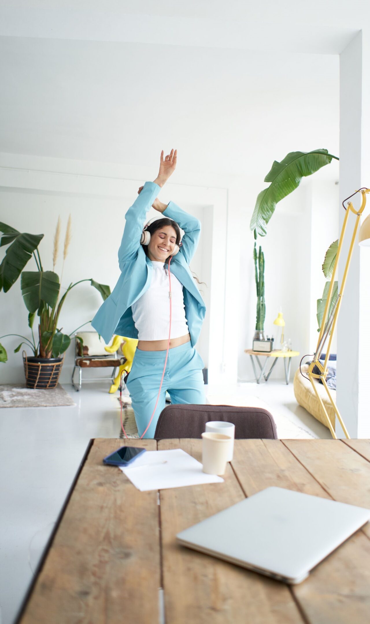 Businesswoman dancing in office with headphones on