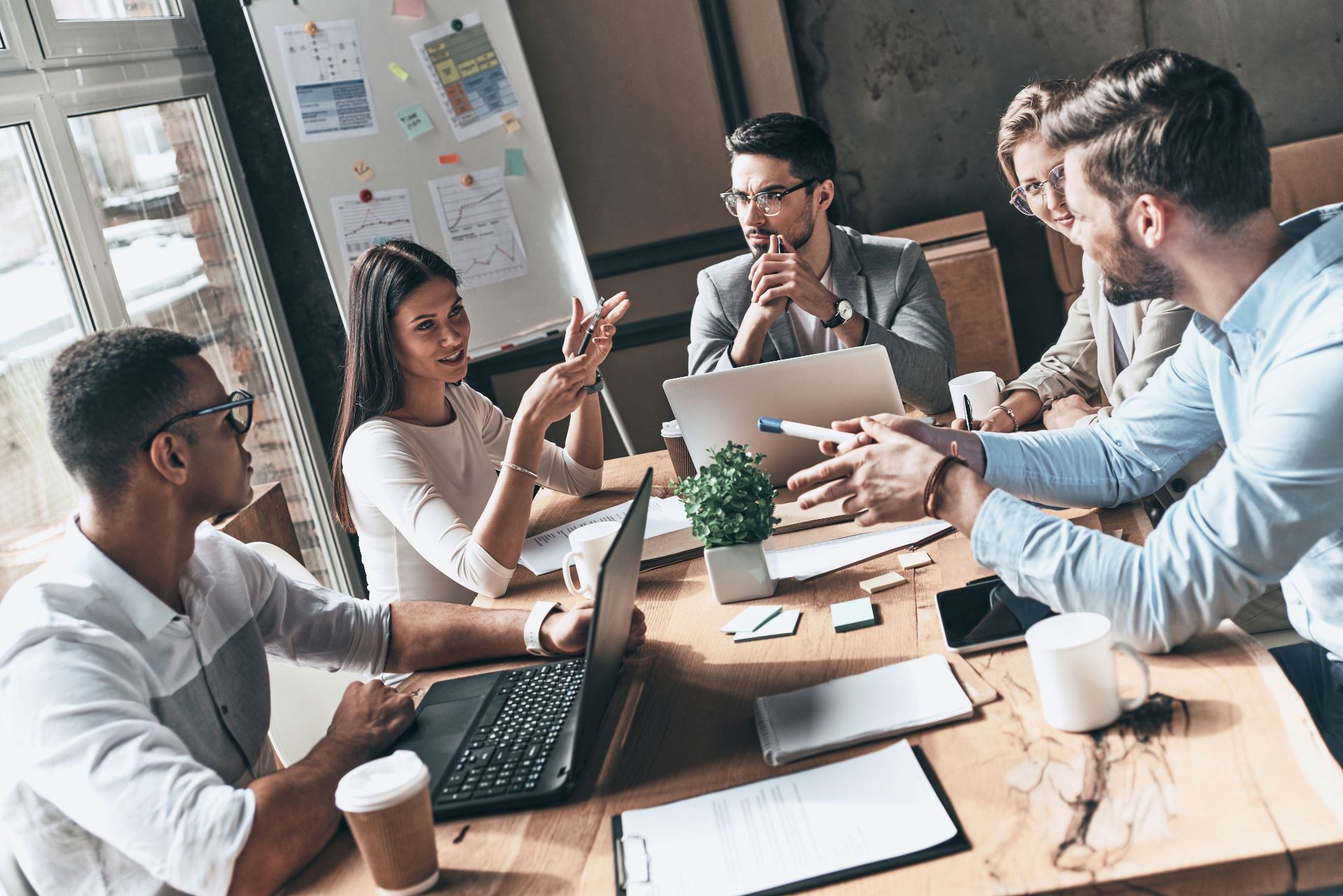 Businesswoman speaking to a group of colleagues around a table.